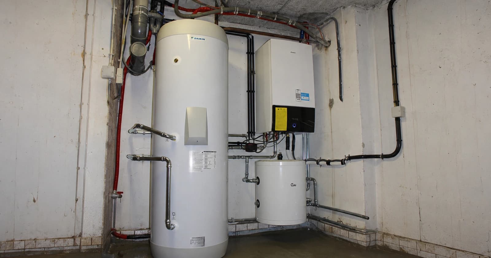 Warmtepompinstallatie met voorraadvat en leidingwerk in een technische ruimte