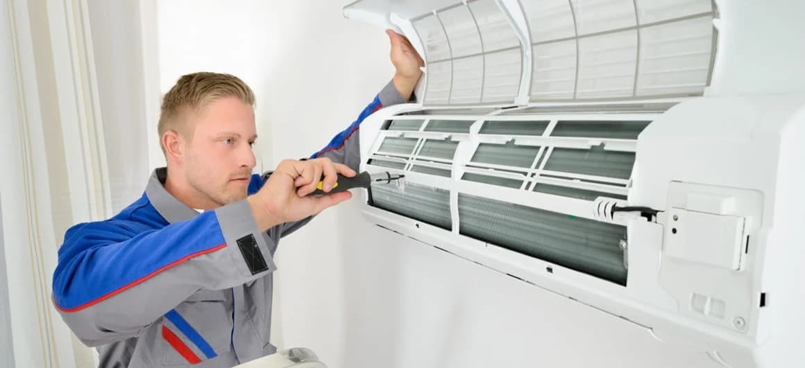 Monteur werkt aan een geopende airco-binnenunit