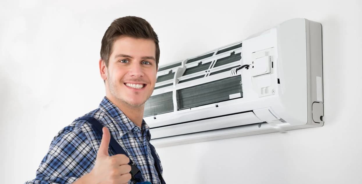 Monteur naast een geopende airco-binnenunit