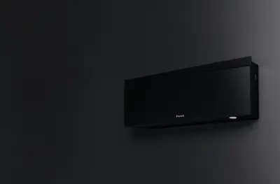Zwarte Daikin Emura airco aan een donkere wand