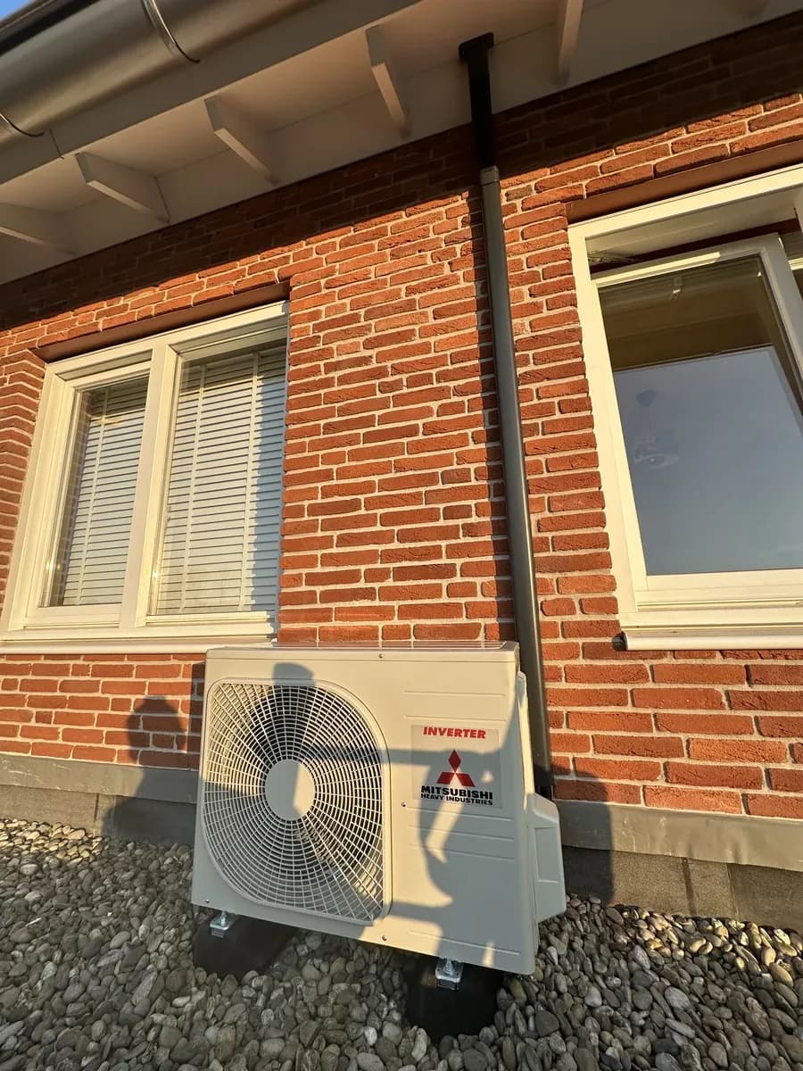 Buitenunit netjes gemonteerd tegen rode gevel Rotterdam